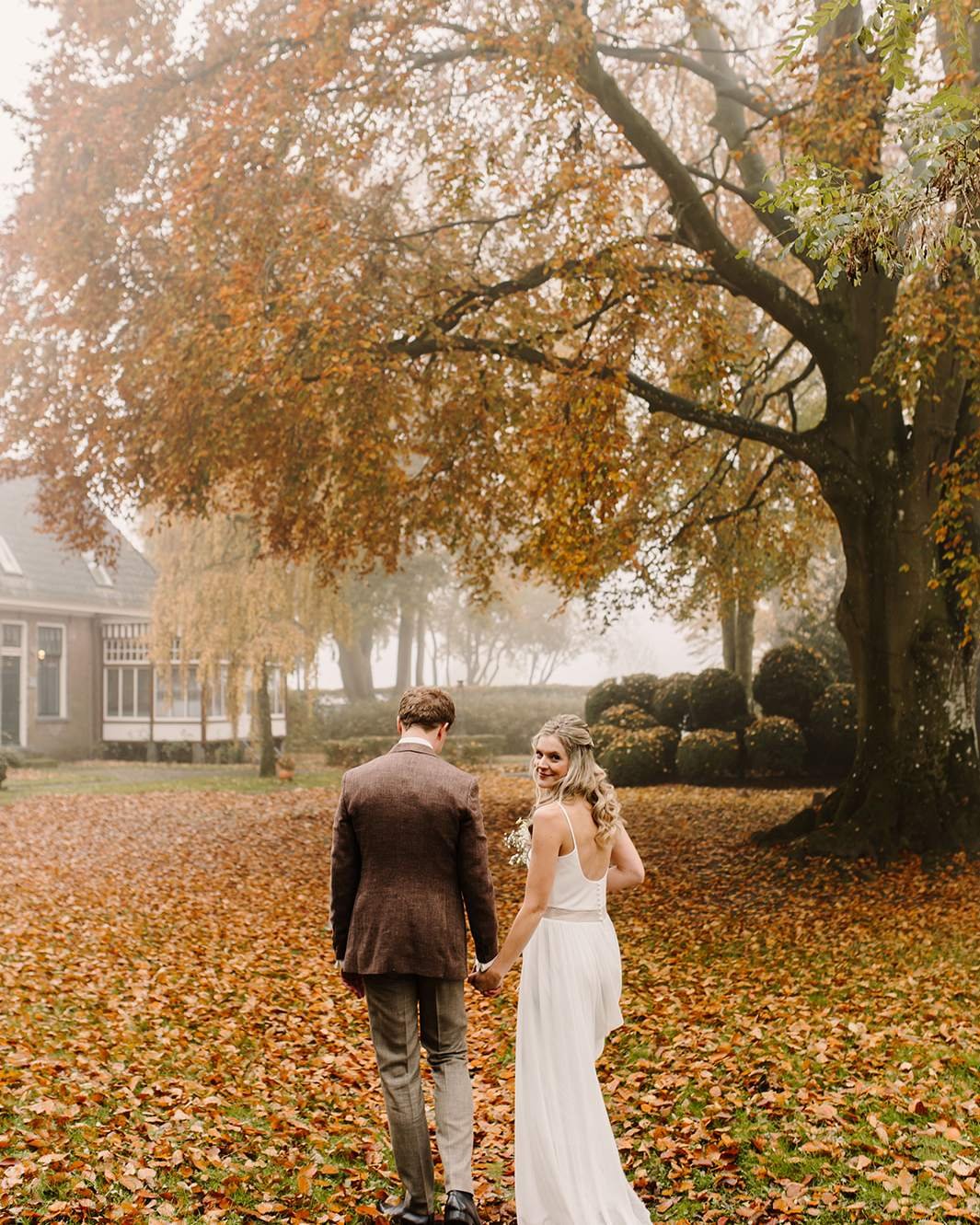 Bruidspaar in de herfstlaan bij De Amshoff