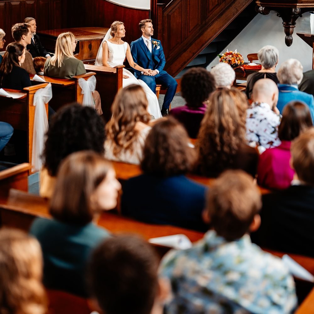 Gasten in de kerkbanken tijdens de ceremonie