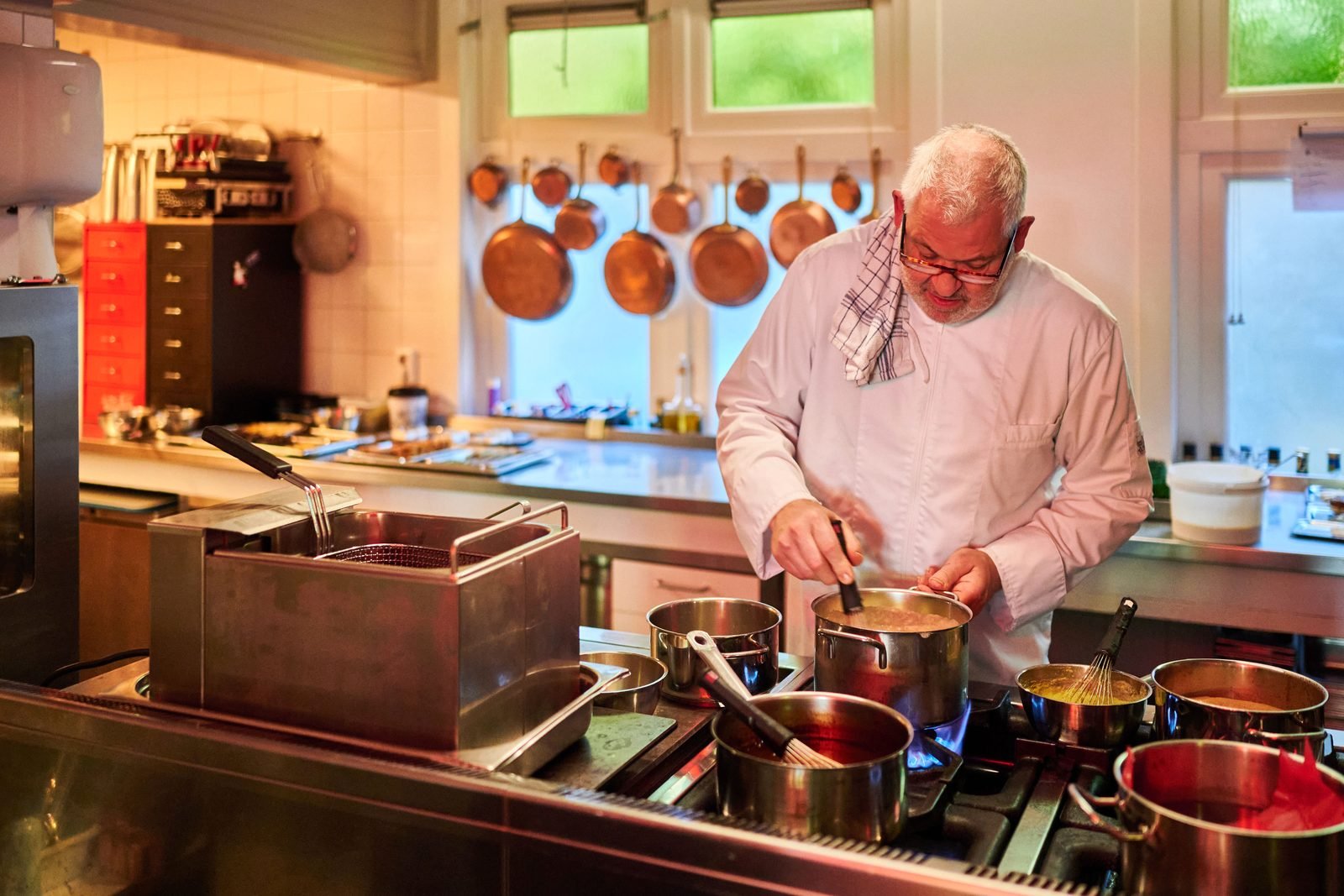 Chef Jan Stams bereidt een gerecht in de keuken van De Amshoff