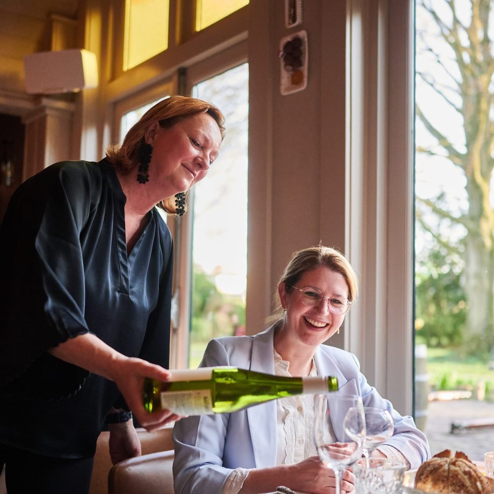 Marola Claessen schenkt wijn in bij restaurant De Amshoff